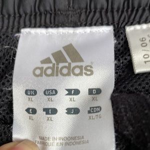 Adidas track pants ,  black with three stripes ,  zipper at the bottom of hem